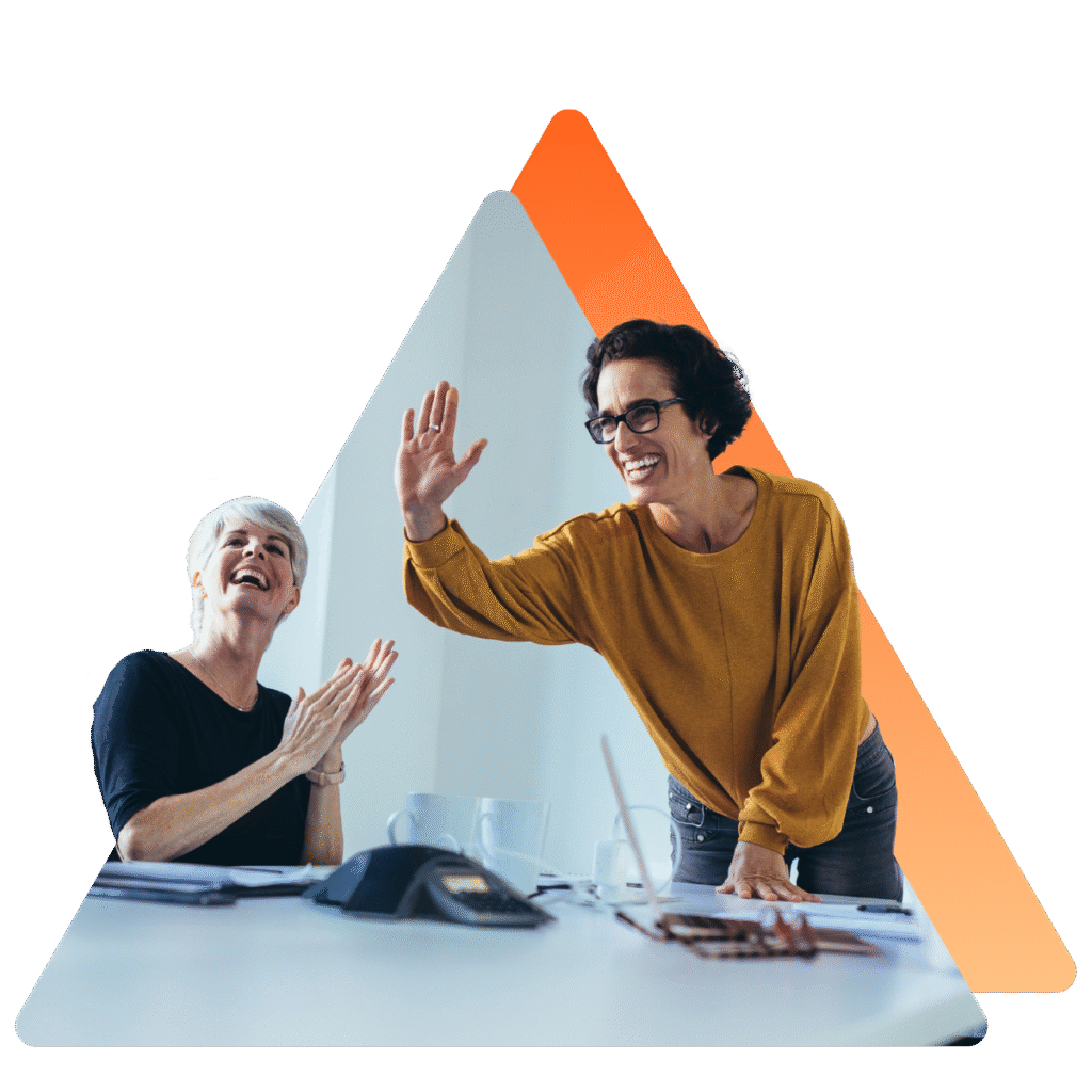 Deux élues CSE se congratulent en se faisant un high-five lors d’une réunion, symbolisant la réussite de leur projet avec VisionCSE.